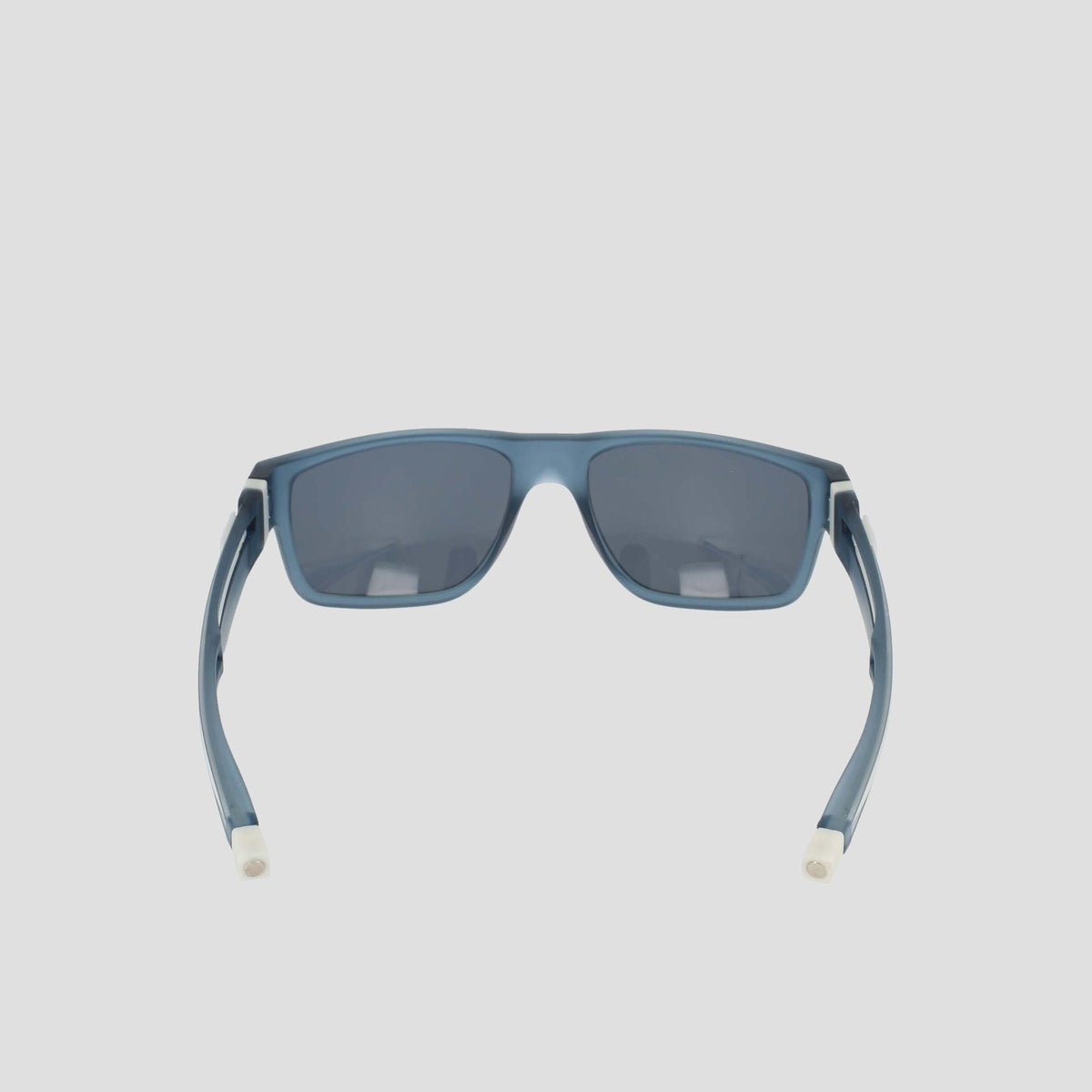 Champion Men's Polarized Retainer Rectangle sunglasses in blue, featuring a rectangular shape with dark polarized lenses. Seen from the back, these high-performance sunglasses highlight their curved arms with white tips and are crafted from durable TR90 material. Displayed against a plain light background.