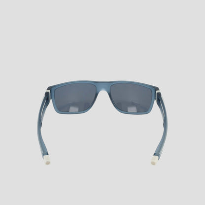 Champion Men's Polarized Retainer Rectangle sunglasses in blue, featuring a rectangular shape with dark polarized lenses. Seen from the back, these high-performance sunglasses highlight their curved arms with white tips and are crafted from durable TR90 material. Displayed against a plain light background.