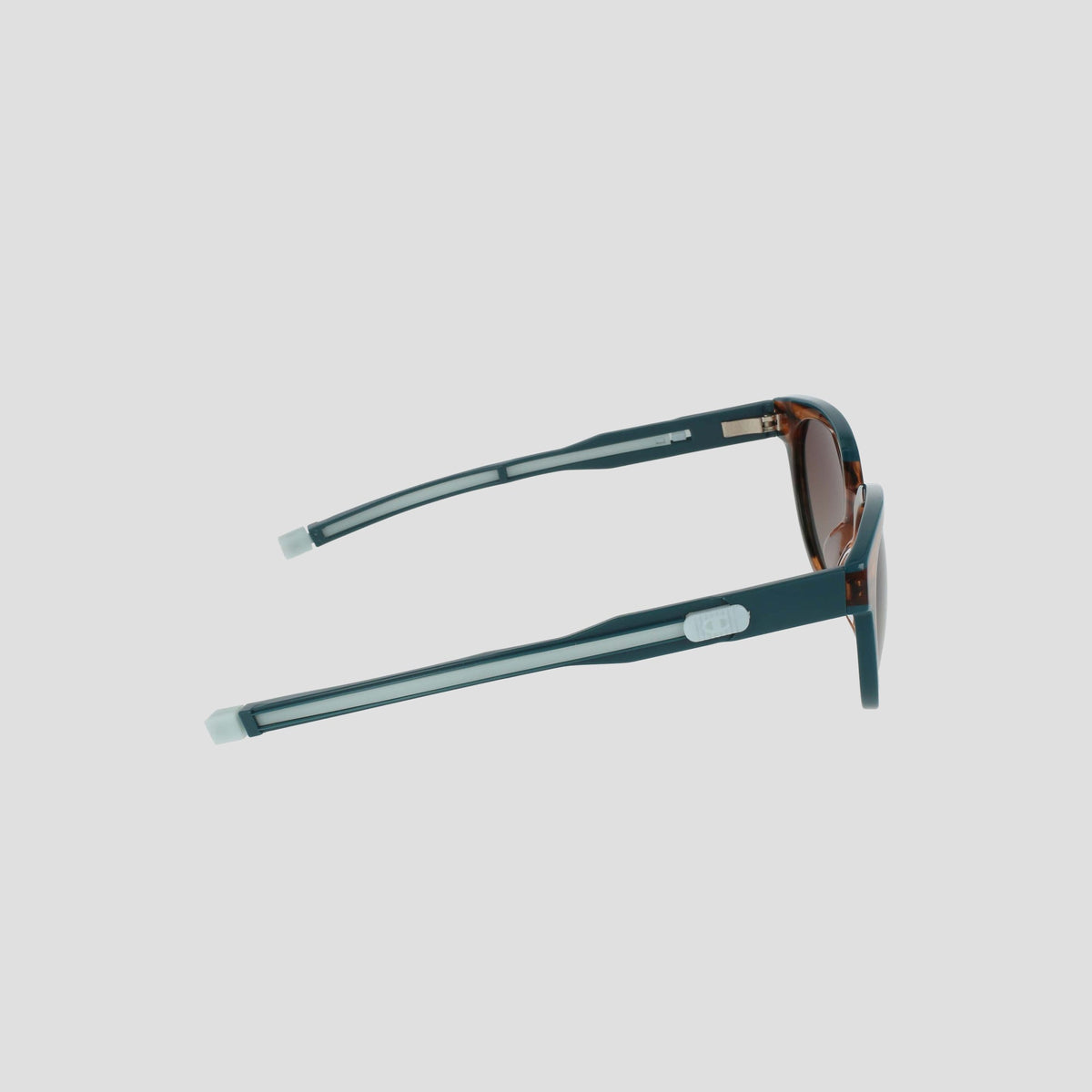 Side view of Champion Women's Polarized Retainer Round eyewear in teal with brown-tinted lenses and silver arm accents, displayed against a plain white background.
