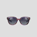 The Champion Women's Polarized Retainer Round sunglasses feature purple translucent round frames and dark tinted lenses, making a bold statement in women’s fashion eyewear, showcased on a plain light gray background.