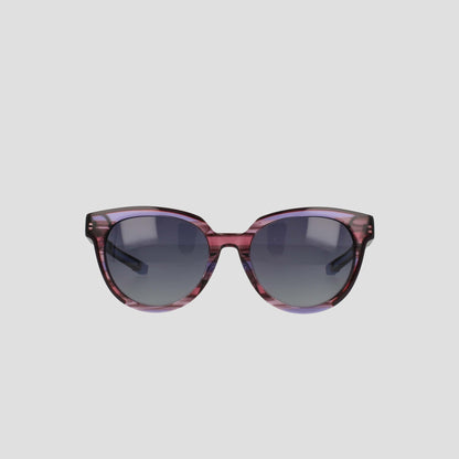 The Champion Women's Polarized Retainer Round sunglasses feature purple translucent round frames and dark tinted lenses, making a bold statement in women’s fashion eyewear, showcased on a plain light gray background.