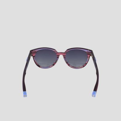 The Champion Women's Polarized Retainer Round features purple frames, dark gradient lenses, and blue-tipped arms, shown against a simple light gray background.