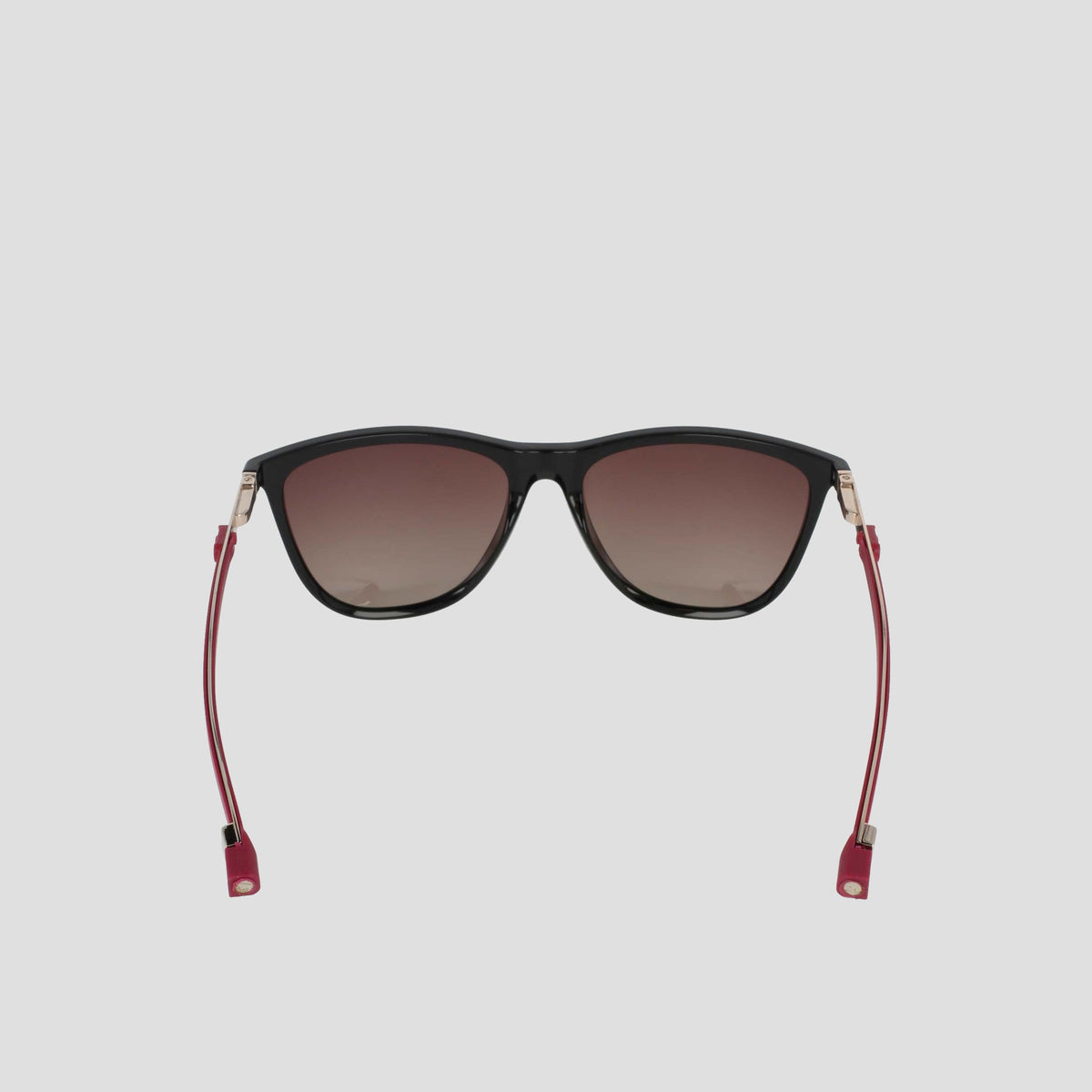 Front-facing view of the Champion Women's Polarized Retainer Rectangle sunglasses, featuring a black cateye design with dark gradient polarized lenses, thin red temples, and gold accents—ideal athleisure eyewear—displayed against a plain light gray background.