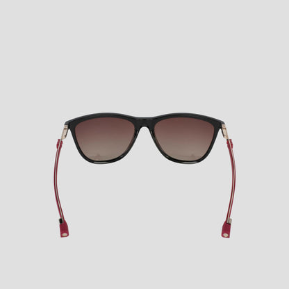 Front-facing view of the Champion Women's Polarized Retainer Rectangle sunglasses, featuring a black cateye design with dark gradient polarized lenses, thin red temples, and gold accents—ideal athleisure eyewear—displayed against a plain light gray background.