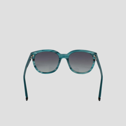 Presenting Champion's Women's Polarized Curvaceous Square sunglasses in a striking teal, crafted from high-shine acetate with square frames and gradient dark-to-light tinted lenses. Shown head-on against a plain white background with both arms extended outward, these modern classic sunglasses feature polarized lenses for superior clarity and protection.