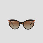 Champion Women's Polarized Cateye sunglasses with a tortoiseshell cat-eye frame, gold accents on the upper corners, and gradient brown polarized lenses featuring RX-able frames, displayed against a plain light gray background.