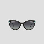 Champion’s Women's Polarized Cateye sunglasses feature black and gray marbled frames, dark gradient lenses, and distinctive teal accents at the upper outer corners. Displayed against a simple light background, these chic cat-eye sunglasses not only offer practical sun protection with their polarized gradient lenses but also elevate your style.