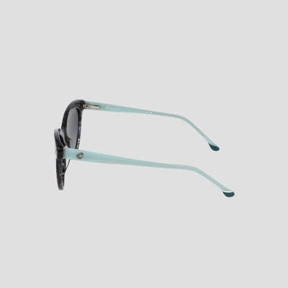 Side view of the Champion Women's Polarized Cateye sunglasses, featuring black and white tortoiseshell frames, light blue arms, and gradient lenses, set against a plain light grey background.