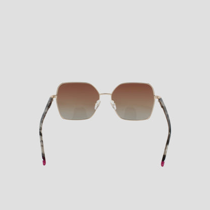 The Champion Women's Polarized Boho Square sunglasses feature a bold square silhouette with gold frames, brown gradient lenses, and thin arms adorned with a marbled pattern and finished with pink tips, showcased against a plain light background.