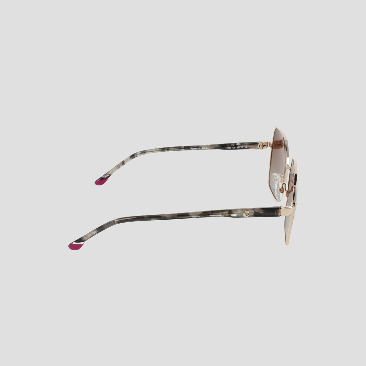 Side view of the Champion Women's Polarized Boho Square sunglasses, showcasing a stylish square silhouette with thin gold metal frames and patterned temples tipped in pink. The light brown lenses feature a subtle gradient tint, all set against a plain light gray background.