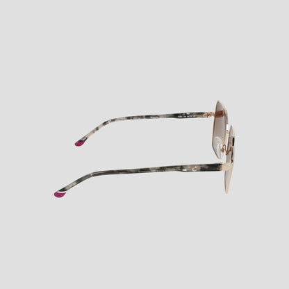 Side view of the Champion Women's Polarized Boho Square sunglasses, showcasing a stylish square silhouette with thin gold metal frames and patterned temples tipped in pink. The light brown lenses feature a subtle gradient tint, all set against a plain light gray background.