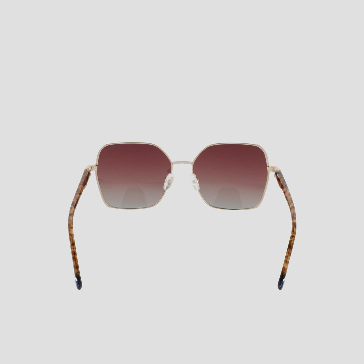 The Champion Women's Polarized Boho Square sunglasses feature gold frames, gradient brown polarized lenses, and tortoiseshell-patterned temple arms for a modern glam look. Displayed on a plain white background, the sunglasses are shown facing forward with their arms slightly angled outward.