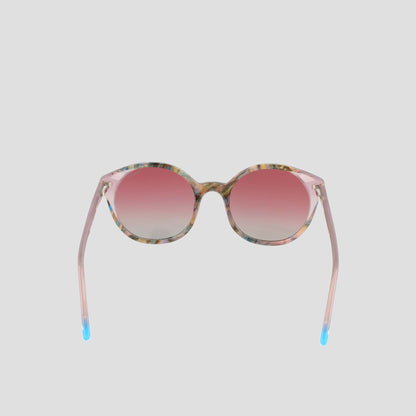 Champion Women's Polarized Flirty Round sunglasses featuring pink gradient polarized lenses, a translucent pink acetate frame, and blue tips on the arms, displayed on a plain light gray background.