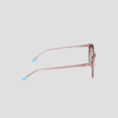 The Champion Women's Polarized Flirty Round sunglasses feature a pink cat-eye silhouette with blue-tipped acetate arms, displayed from the side against a plain light gray background.
