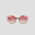 The Champion Women's Polarized Flirty Round sunglasses, featuring a multicolored acetate frame and pink gradient lenses, are displayed against a plain light gray background.