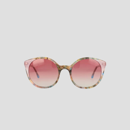 The Champion Women's Polarized Flirty Round sunglasses, featuring a multicolored acetate frame and pink gradient lenses, are displayed against a plain light gray background.