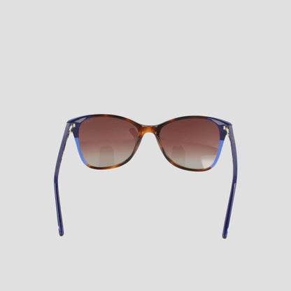 A pair of Women's Polarized Catty Square sunglasses by Champion, featuring gradient brown polarized lenses and blue, RX-able frames crafted from handmade acetate eyeglasses material for enhanced durability and comfort. The stylish design is shown from the front against a plain light background.