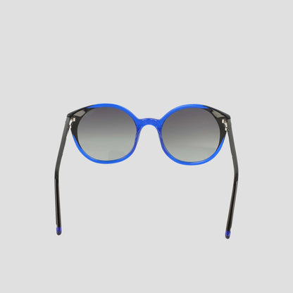 The Women's Polarized Flirty Round sunglasses by Champion feature a bright blue handmade acetate frame and dark gradient lenses, displayed against a plain light gray background.