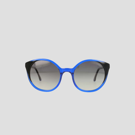 Champion's Women's Polarized Flirty Round sunglasses, featuring blue rims, black temples, and gradient lenses in handmade acetate for a refined finish, are displayed against a plain light gray background.