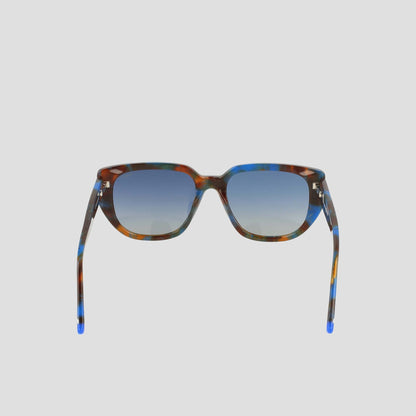 Front view of the Champion Women's Polarized Modified Cateye sunglasses featuring a handmade multicolored tortoiseshell acetate frame and blue gradient lenses, set against a plain light gray background.