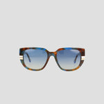 Front view of the Champion Women's Polarized Modified Cateye sunglasses featuring oversized square handmade acetate frames in a multicolored tortoiseshell pattern, gradient blue polarized lenses, and two white stripes on each temple, set against a plain light background.