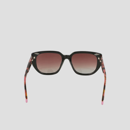 Introducing the Champion Women's Polarized Modified Cateye sunglasses, featuring black frames, gradient pink-tinted polarized lenses, and tortoiseshell arms with pink tips—displayed against a plain white background.