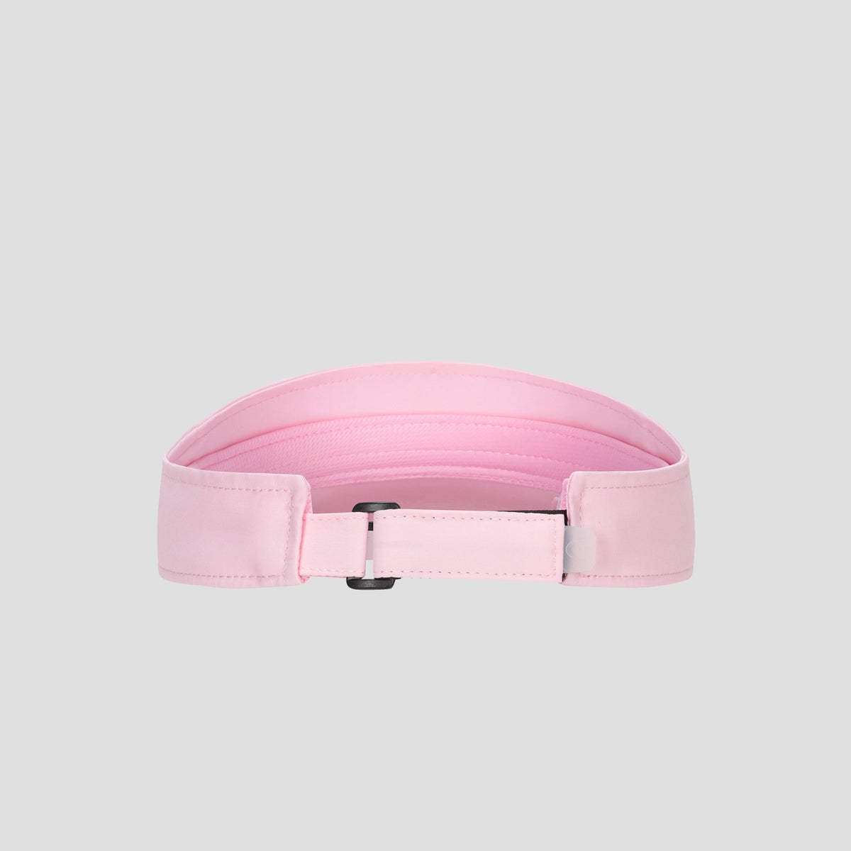 A light pink Champion Adjustable Visor featuring stitching detail, a rectangular black buckle, and a smooth texture offers both style and an adjustable fit, displayed on a plain gray background.