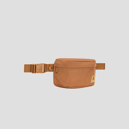 The Champion Atlas Waist Pack in tan, showcasing a front zipper pocket and an adjustable strap for hands-free convenience, is displayed against a plain light gray background.
