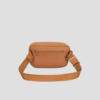 Champion Atlas Waist Pack in tan canvas, featuring an adjustable strap and a front zippered pocket for hands-free convenience, displayed against a plain light gray background.