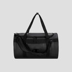 The Champion Approach Convertible Duffel is a black bag featuring a shoulder strap, dual handles, a front zippered pocket, and an understated side logo. Set against a plain light gray background, it’s ideal for versatile use as both a weekend bag and gym bag.