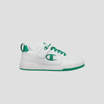 The Champion Kids' Arena Power Low sneaker features a white design with green accents, green laces, a green side logo, plus a green sole and heel tab. Shown on a light gray background, it delivers classic Champion style for kids.