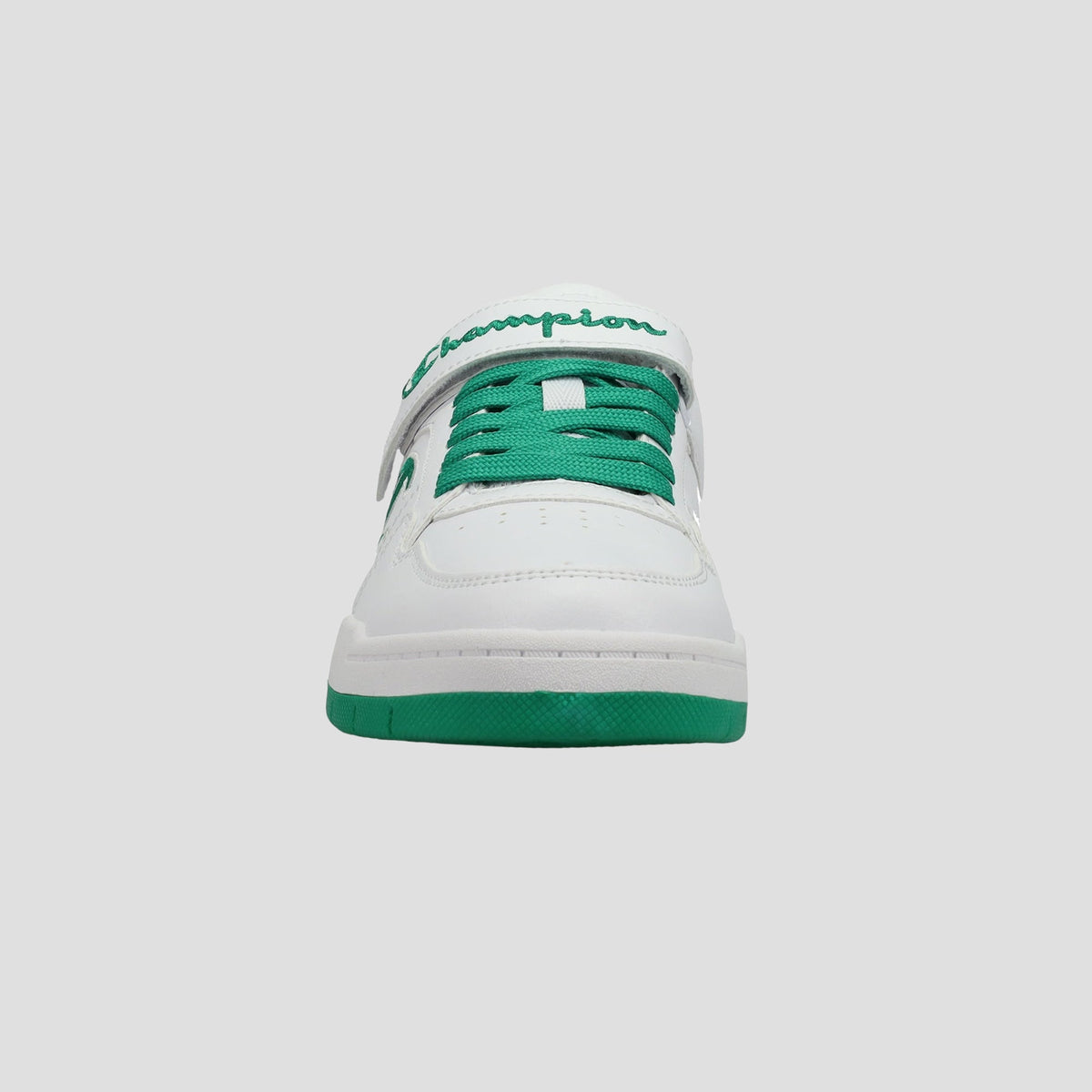 Front view of the Champion Kids' Arena Power Low sneaker in white, featuring green laces and sole, with "Champion" in green on the tongue, showcasing classic style for kids against a plain light gray background.