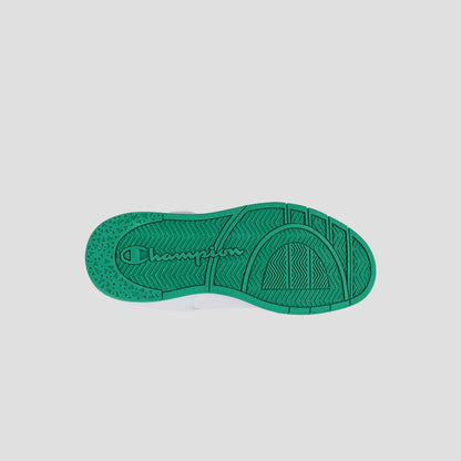 The bottom view of a green Kids' Arena Power Low sneaker by Champion shows a textured sole with "Champion" embossed in the center, set against a plain white background.