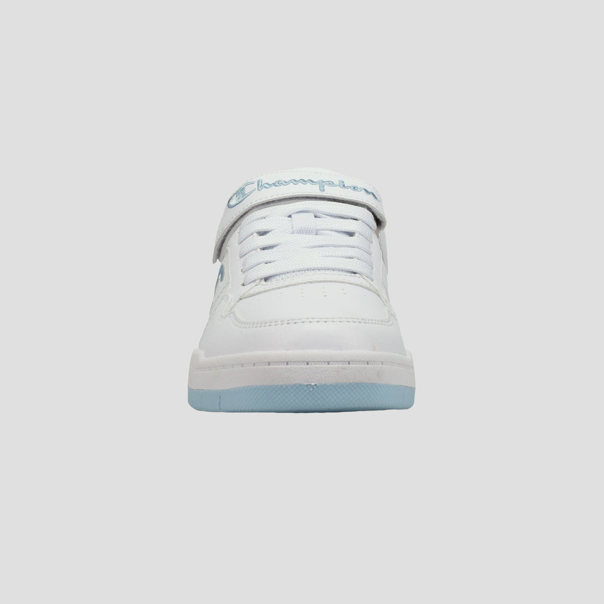 Front view of a white Champion Kids' Arena Power Low sneaker with light blue accents, white laces, and "Champion" in blue script on the tongue strap, isolated on a light gray background.