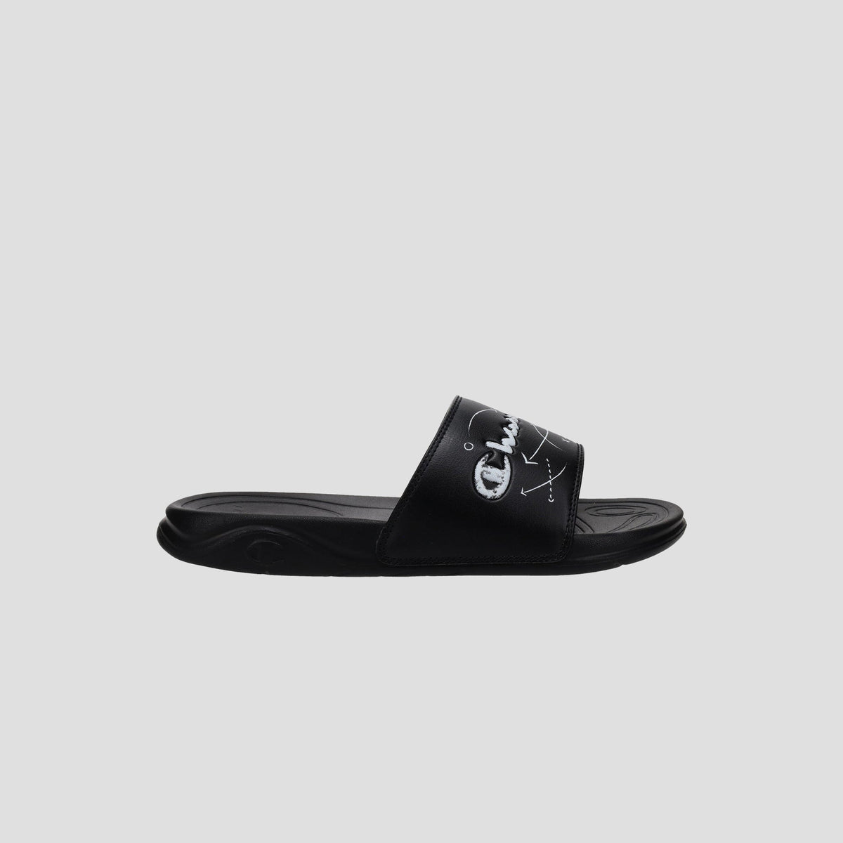 The Champion Kids' Mega SFB Slide is a black sandal with a thick strap, white logo and design, shown from the side on a light gray background. It features a contoured footbed for lightweight comfort.