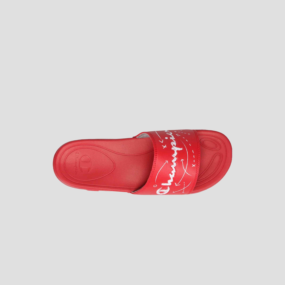 A top view of the Champion Men's Mega SFB Slide shows a single red slide sandal with a contoured footbed and a wide strap featuring white graphic designs and cursive text, set against a light gray background.