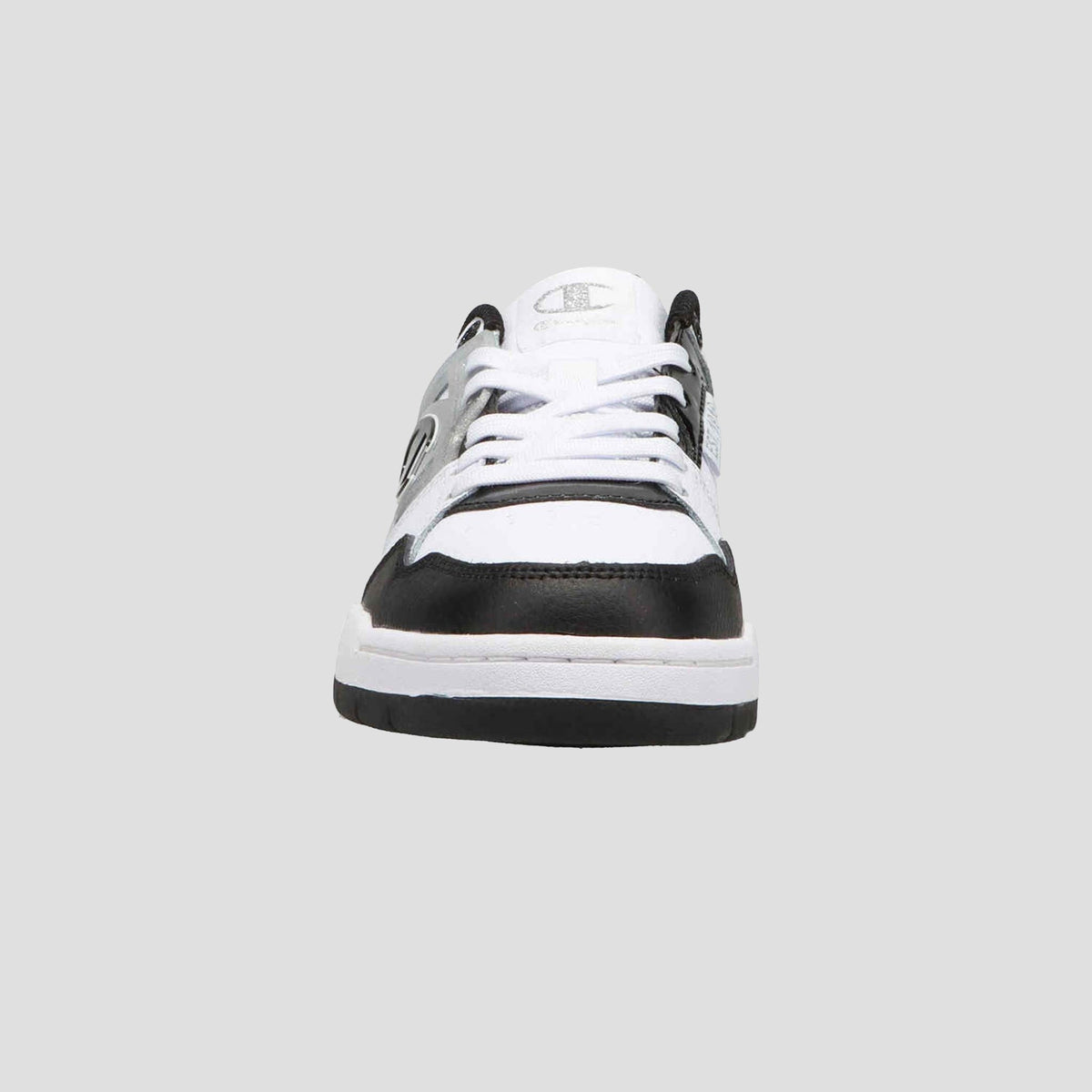 Front view of Champion Women's 5-on-5 Low sneaker in black and white, featuring minimalist design, white laces, black accents on toe and sides, cushioned collar, and Champion logo on the tongue against a plain gray background.