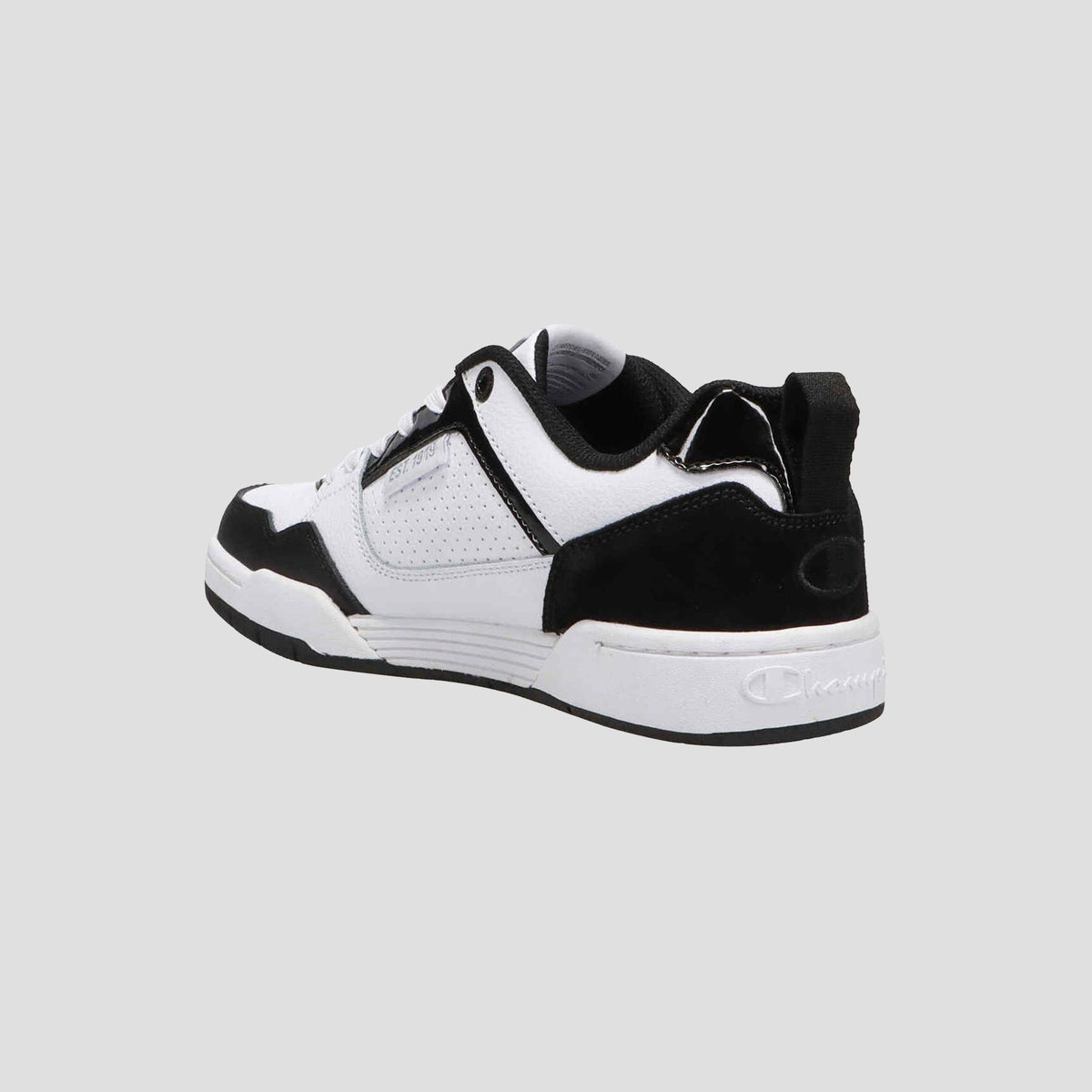 The Champion Women's 5-on-5 Low sneaker features a black and white minimalist design with a cushioned collar, suede accents, and a white sole, shown from the back left angle against a plain light gray background.