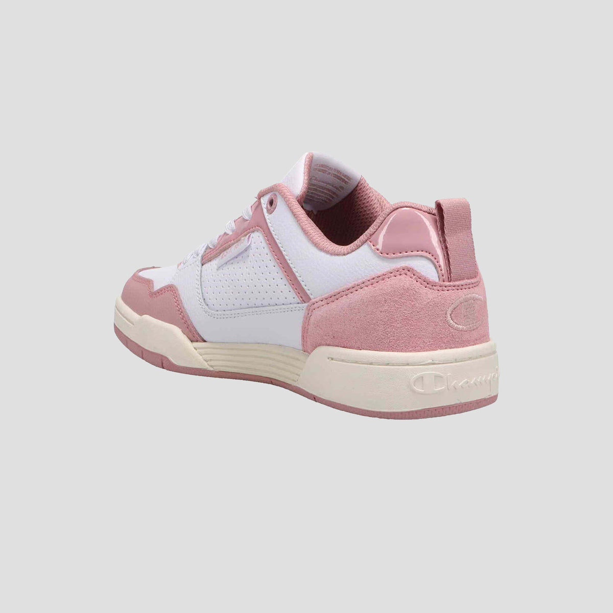 The Champion Women's 5-on-5 Low is a pink and white sneaker with suede and perforated leather details, plus a cushioned collar, shown from back and side angles on a light gray background.