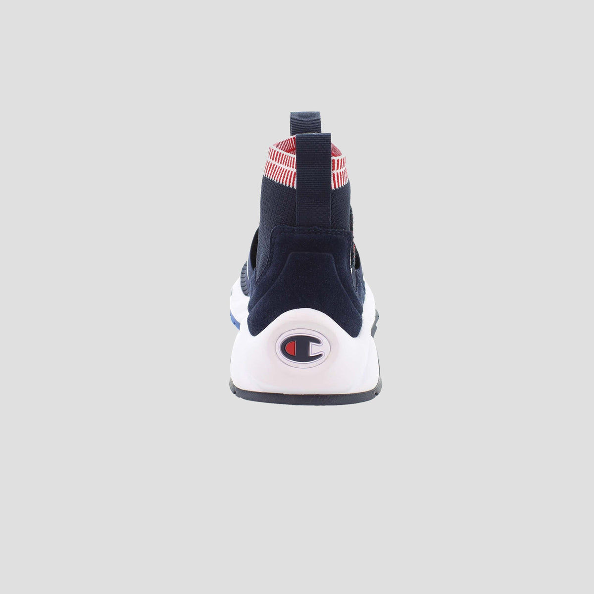The Champion Men's Rally Pro slip-on sneaker in navy blue is shown from the back, with a white sole featuring the Champion logo, a red-and-white striped heel detail, a cushioned insole, and set against a plain light gray background.