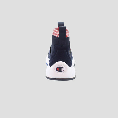 The Champion Men's Rally Pro slip-on sneaker in navy blue is shown from the back, with a white sole featuring the Champion logo, a red-and-white striped heel detail, a cushioned insole, and set against a plain light gray background.