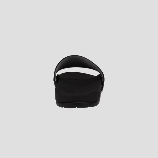 A black Champion Men's IPO Squish Slide sandal viewed from the back displays an open heel, curved strap, contoured footbed, and textured sole against a plain light gray background.