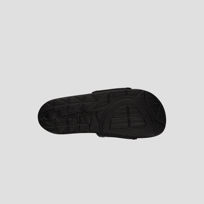The image shows the bottom view of a black Champion Men's IPO Squish Slide sandal with a textured, geometric-patterned sole and embossed branding on a plain light gray background.