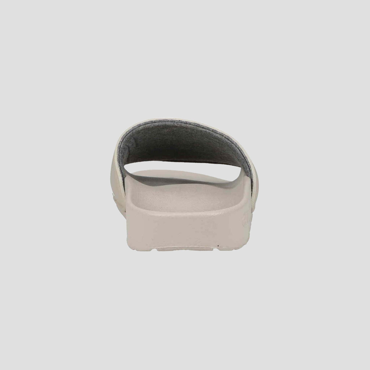 A Champion Women's IPO Slide in beige, shown from the back with an open heel and contoured footbed, offers lightweight comfort against a plain, light background.