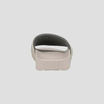 A Champion Women's IPO Slide in beige, shown from the back with an open heel and contoured footbed, offers lightweight comfort against a plain, light background.