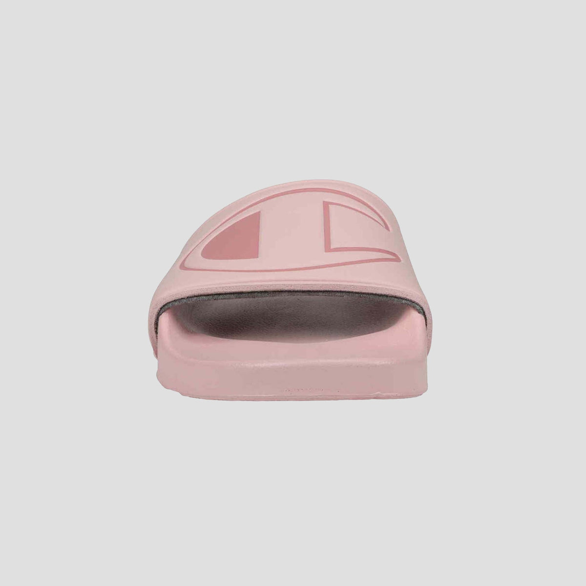 Front view of the Champion Women's IPO Slide in pink, featuring a wide strap with logo design and a contoured footbed, set against a plain light background.