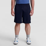 A man stands facing forward against a plain white background, wearing a blue shirt, gray socks, white sneakers, and Champion 10" Moisture Wicking Sport Shorts - Big & Tall. His head is not visible in the image.