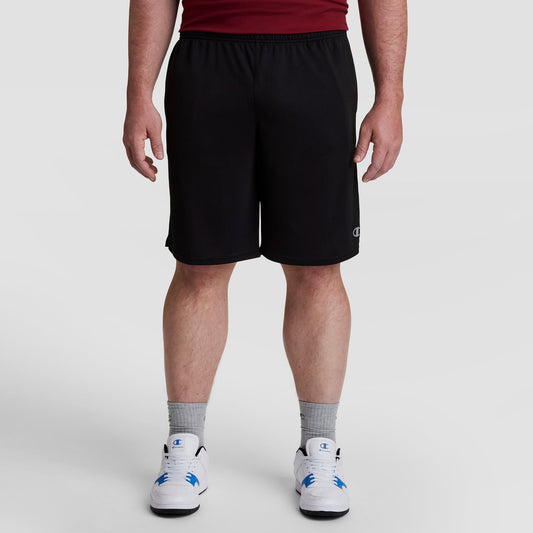 A person wearing Champion 10" Moisture Wicking, Sport Shorts - Big & Tall, a red shirt, gray socks, and white sneakers stands against a plain light background. Only their lower half is visible.