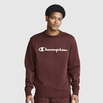 A person wearing a maroon Champion Powerblend Crewneck Sweatshirt, Classic Script Logo, along with matching pants stands against a plain light gray background, facing forward with a neutral expression. The cozy crewneck from Champion adds to the casual yet stylish look.