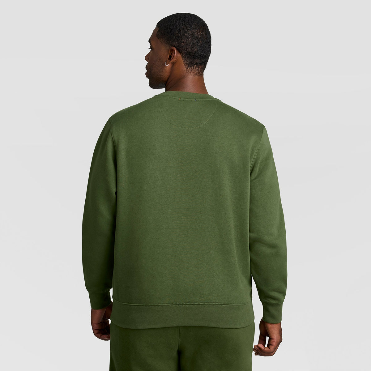 A man seen from behind wearing an olive green Champion Powerblend Crewneck Sweatshirt, C Logo - Big & Tall.